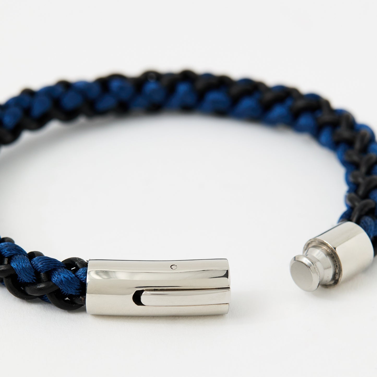 Blue and black braided bracelet with silver clasp on a white background