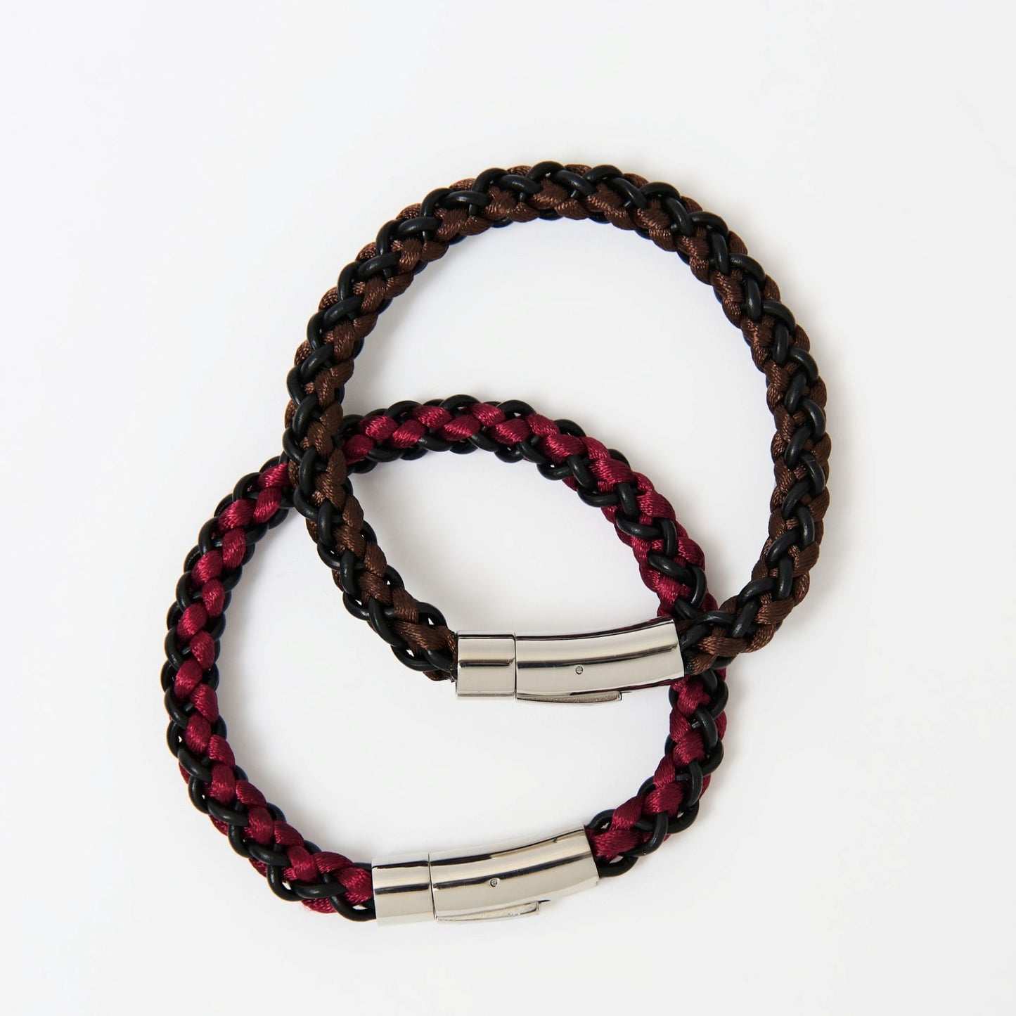 Two braided bracelets with metal clasps on a white background