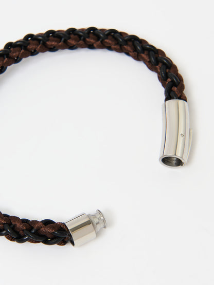 Close-up of a braided bracelet featuring intertwined brown and black materials with stainless steel magnetic clasp ends, displayed on a white background.