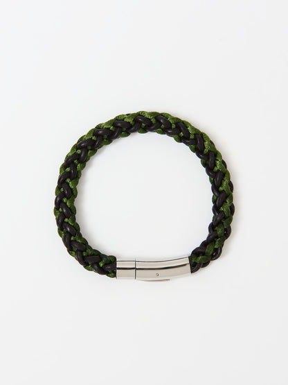 Close-up of a braided bracelet featuring intertwined green and brown materials with stainless steel magnetic clasp, displayed on a white background.