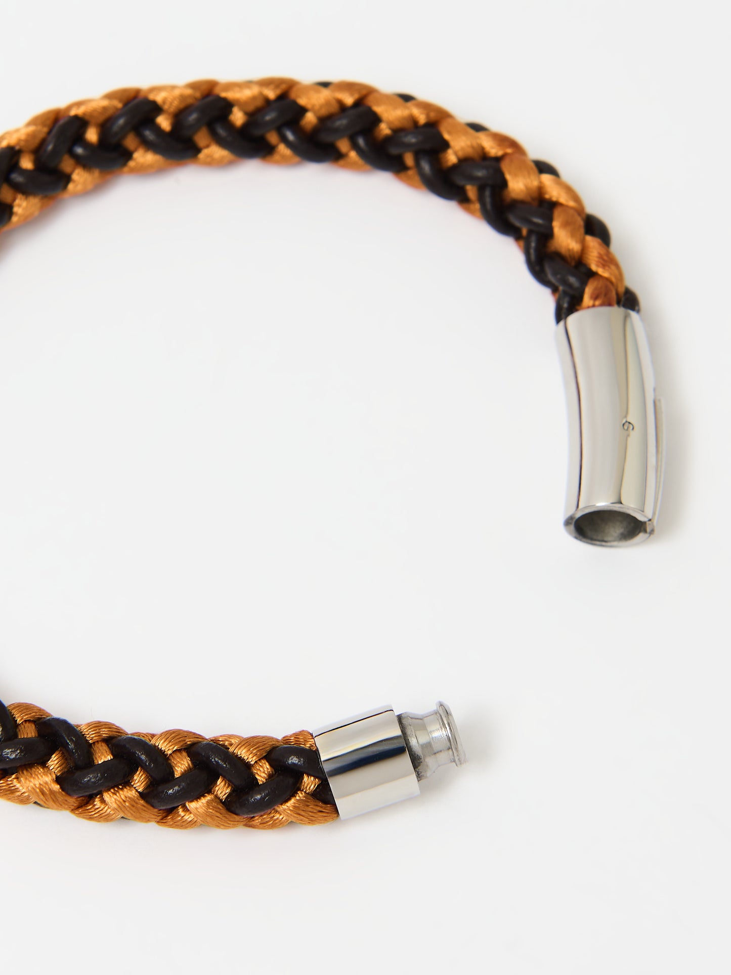 Close-up of a braided bracelet featuring intertwined orange and brown materials with stainless steel magnetic clasp ends, displayed on a white background.