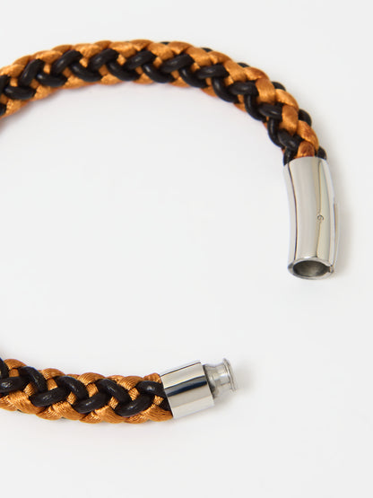 Close-up of a braided bracelet featuring intertwined orange and brown materials with stainless steel magnetic clasp ends, displayed on a white background.