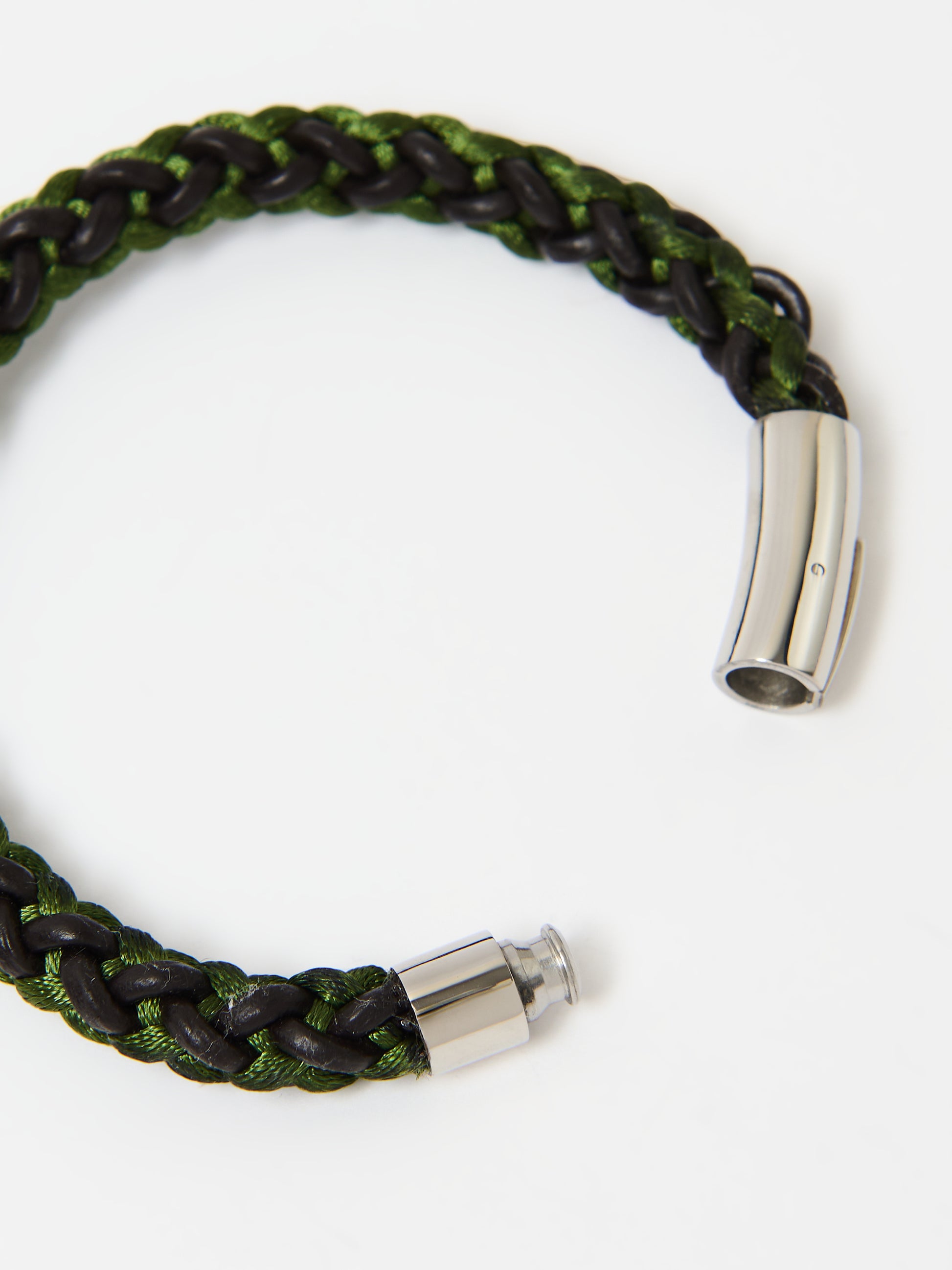 Close-up of a braided bracelet featuring intertwined green and brown materials with stainless steel magnetic clasp ends, displayed on a white background.