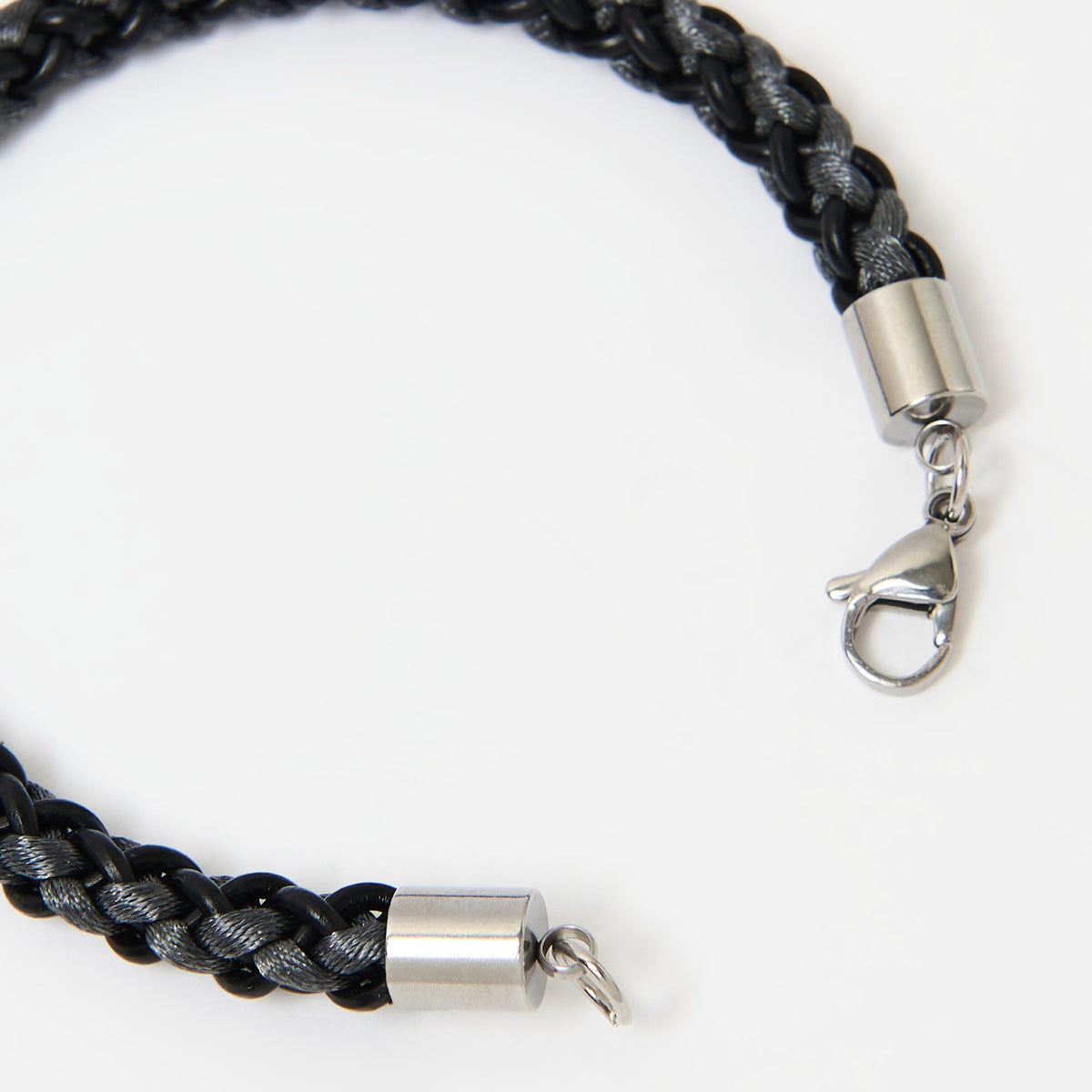 Close-up of the Marlowe braided leather bracelet in Midnight Black with Graphite Grey and its silver lobster clasp