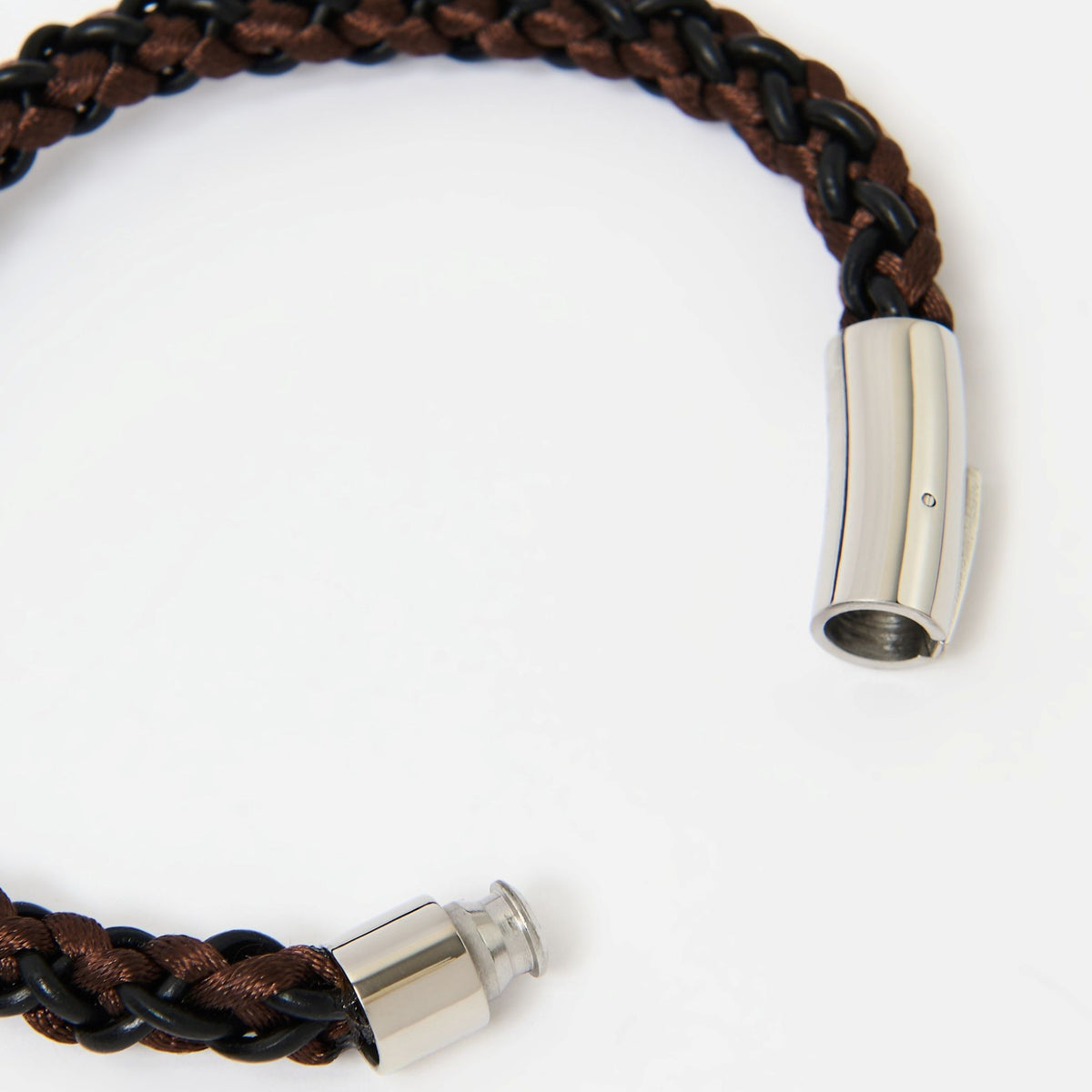 Close-up of the Arden braided leather bracelet in Chestnut Brown and its polished silver magnetic clasp