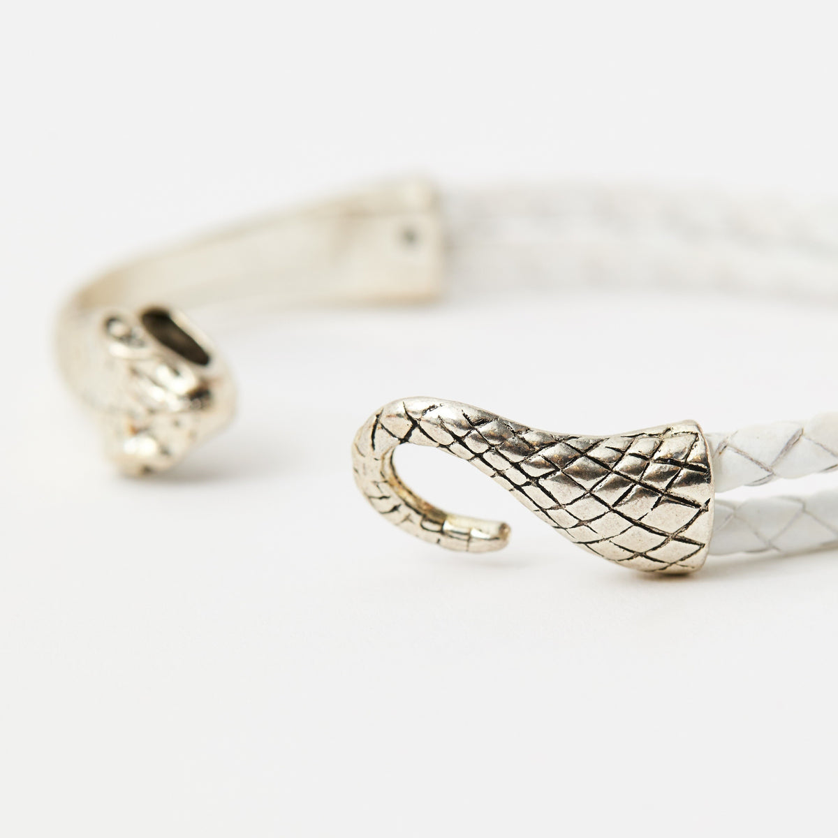 Close-up of the Serin Ivory White braided leather bracelet and its textured silver snake clasp