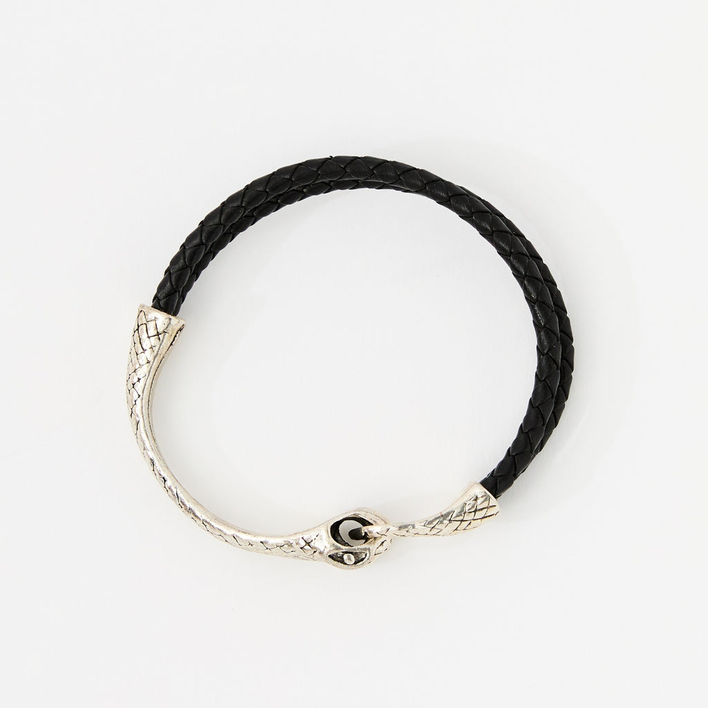 The Serin leather bracelet in Midnight Black with a sculptural silver snake clasp, laid flat on white
