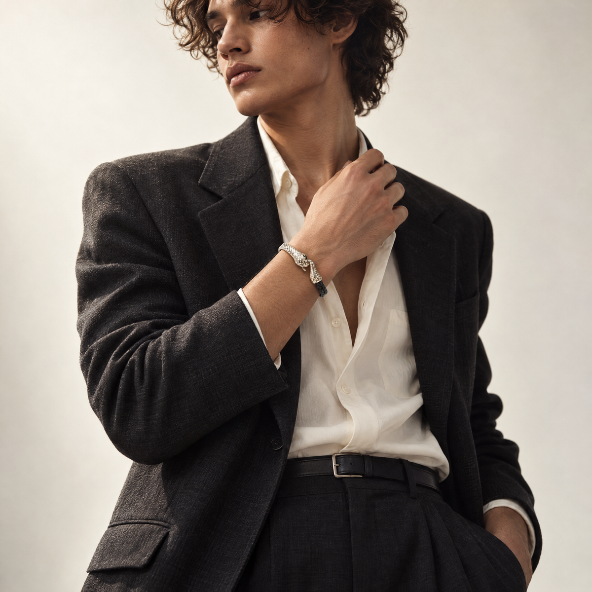 Man wearing the Serin Midnight Black leather bracelet with a sculptural silver snake clasp