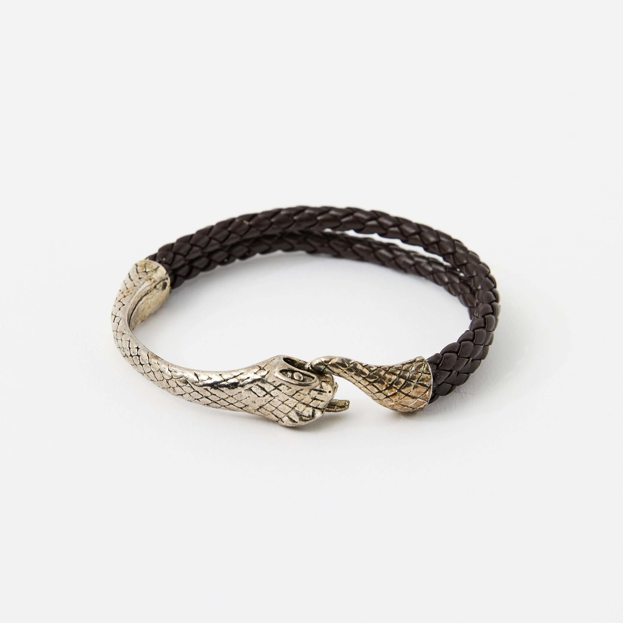 Brown braided leather bracelet with a silver snake head clasp, featuring intricate scale details and a sleek, minimalistic design.