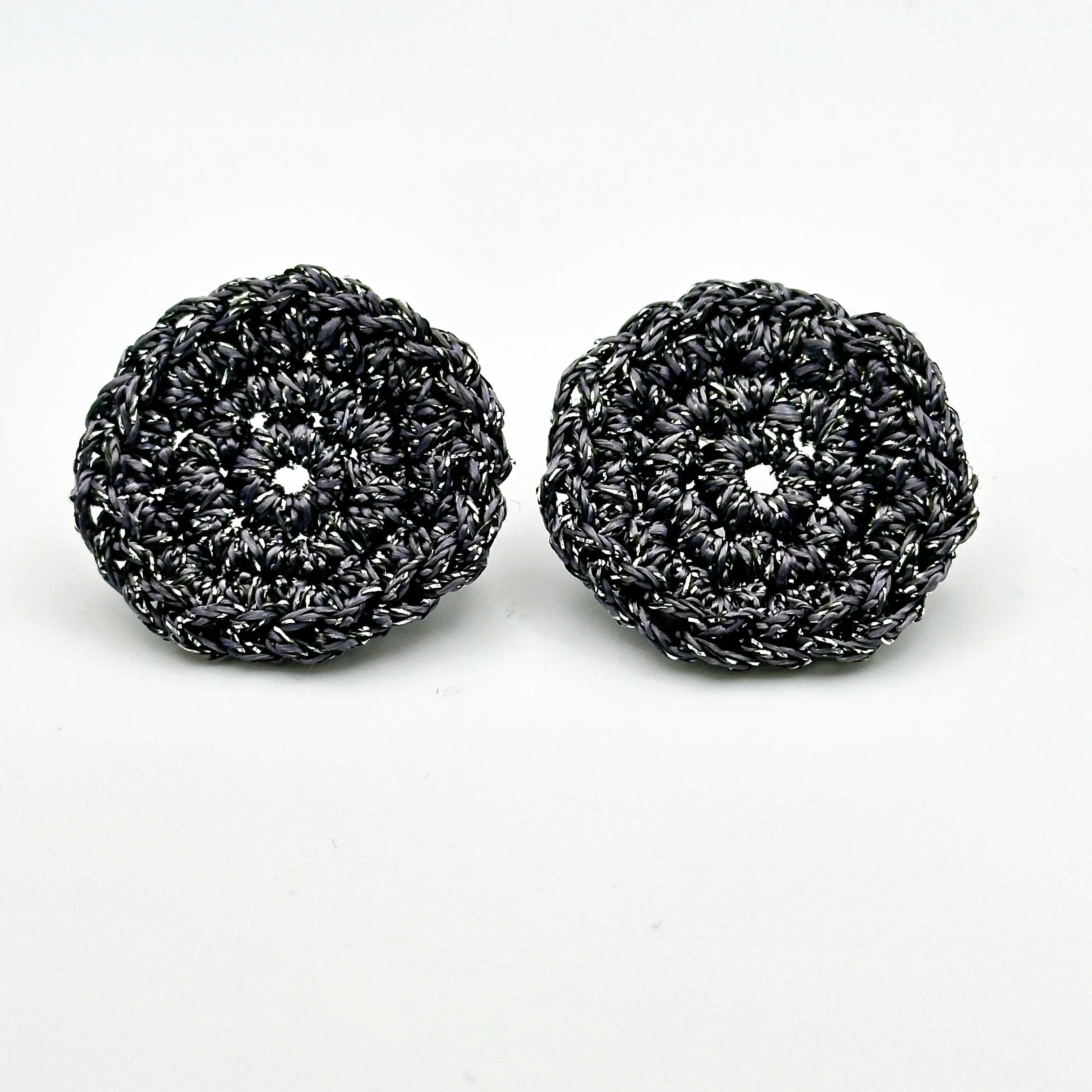 Charcoal grey disc earrings featuring a round, handwoven crochet texture with a reflective, metallic accent for a modern look.