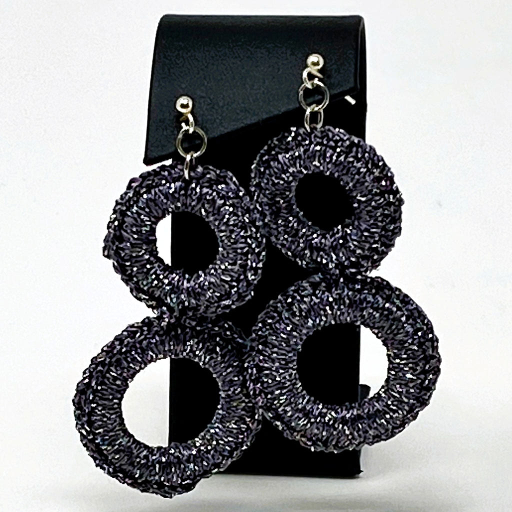 The Sienna charcoal grey crochet double-ring earrings displayed on a black card - Lodorfo