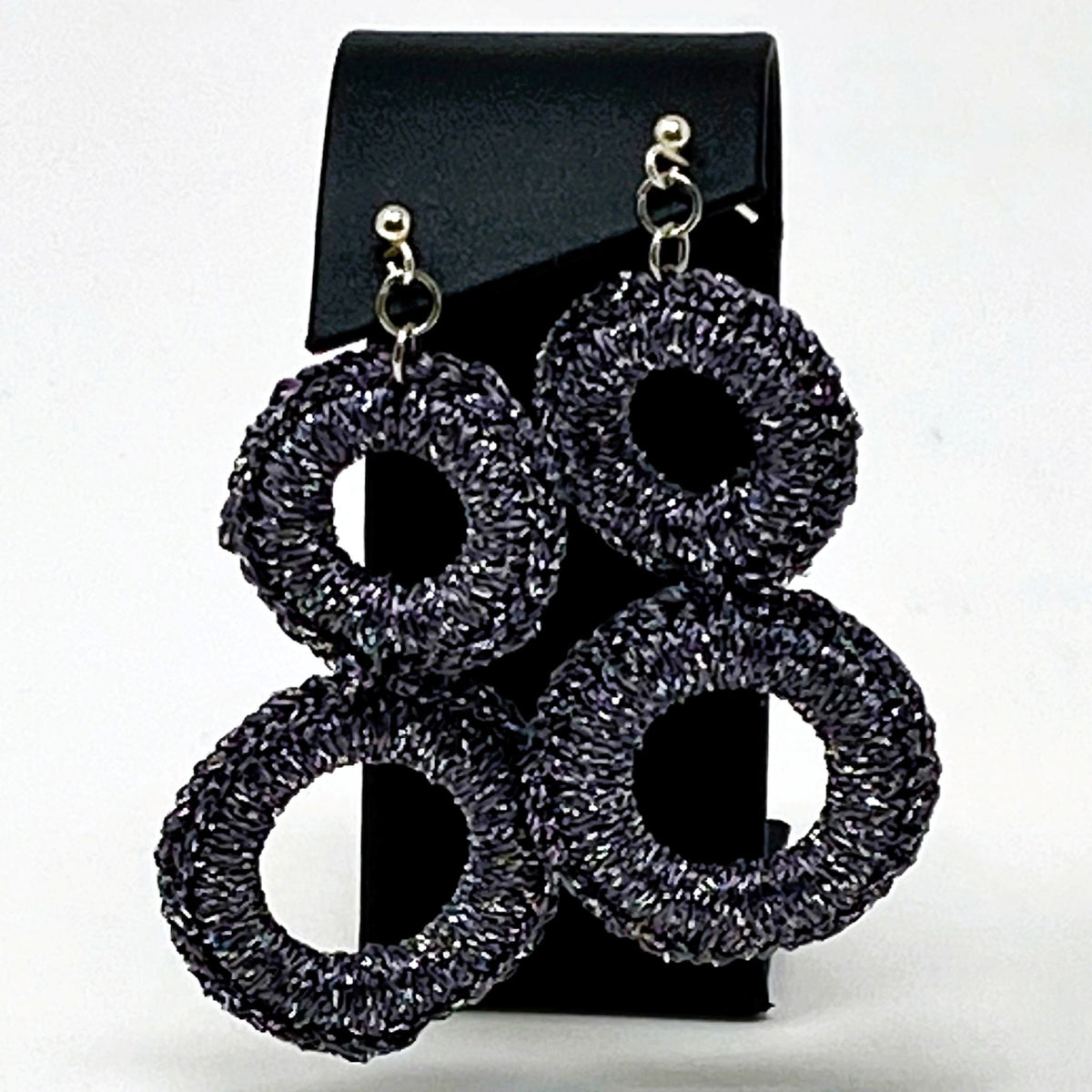 The Sienna charcoal grey crochet double-ring earrings displayed on a black card - Lodorfo