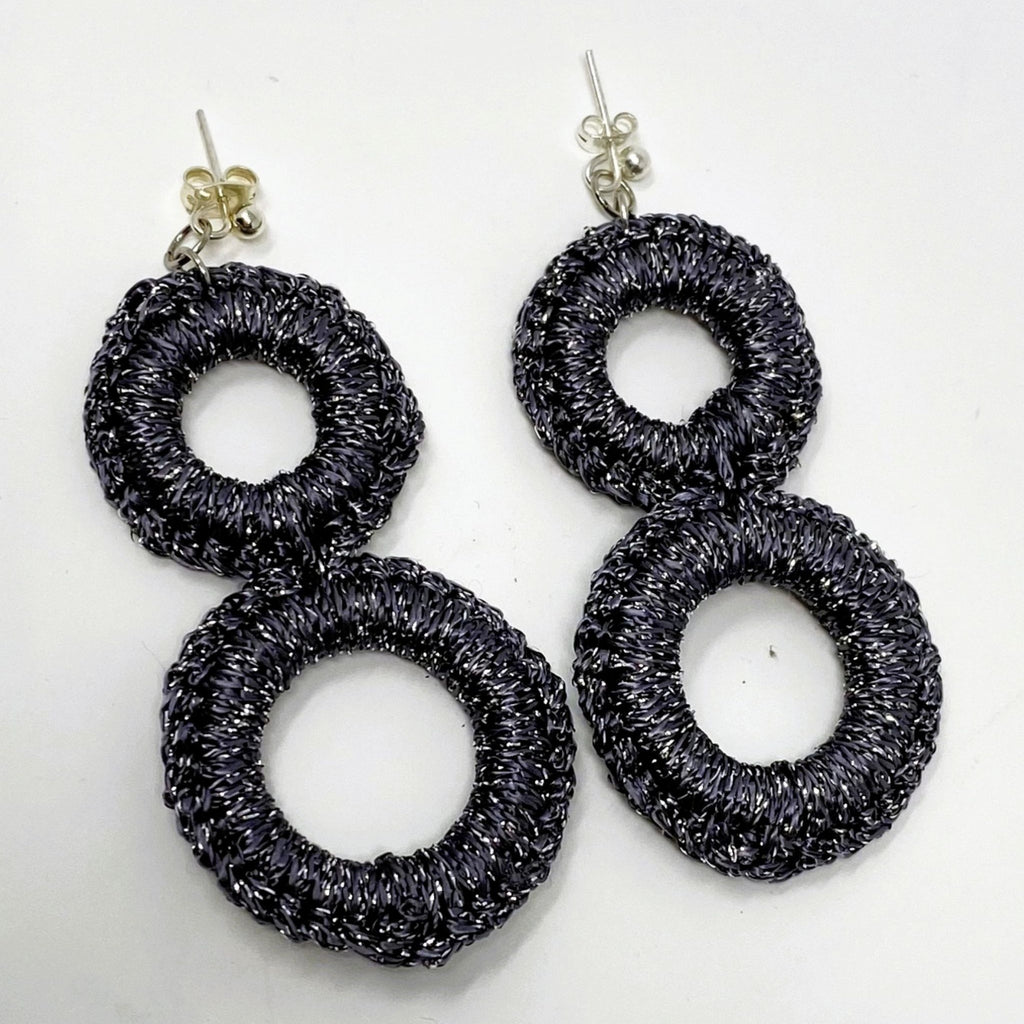 The Sienna charcoal grey crochet double-ring drop earrings with silver sparkle, laid flat - Lodorfo