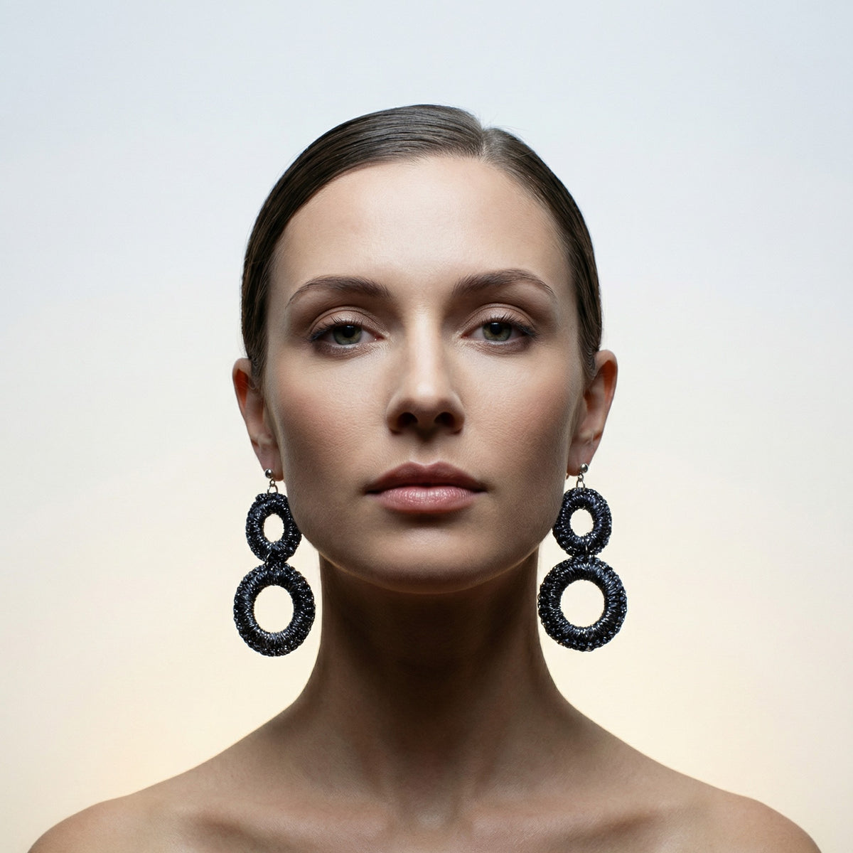 Woman with her hair back wearing the Sienna charcoal grey crochet double-ring drop earrings - Lodorfo