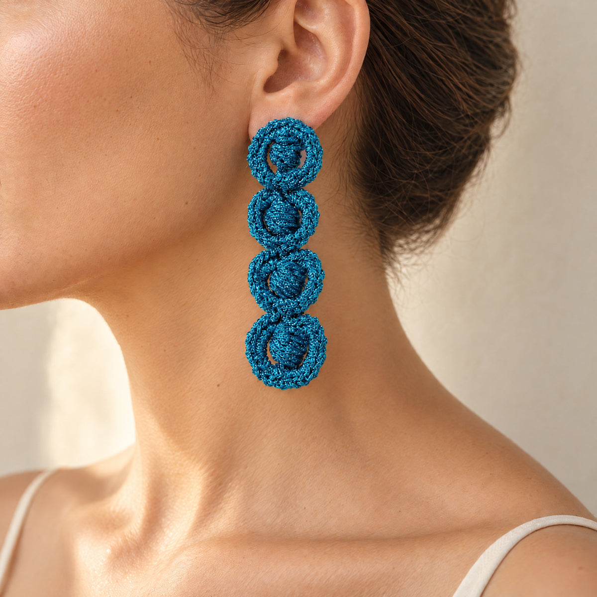 Woman wearing the Arlo long deep teal four-ring crochet loop earring, handmade UK - Lodorfo