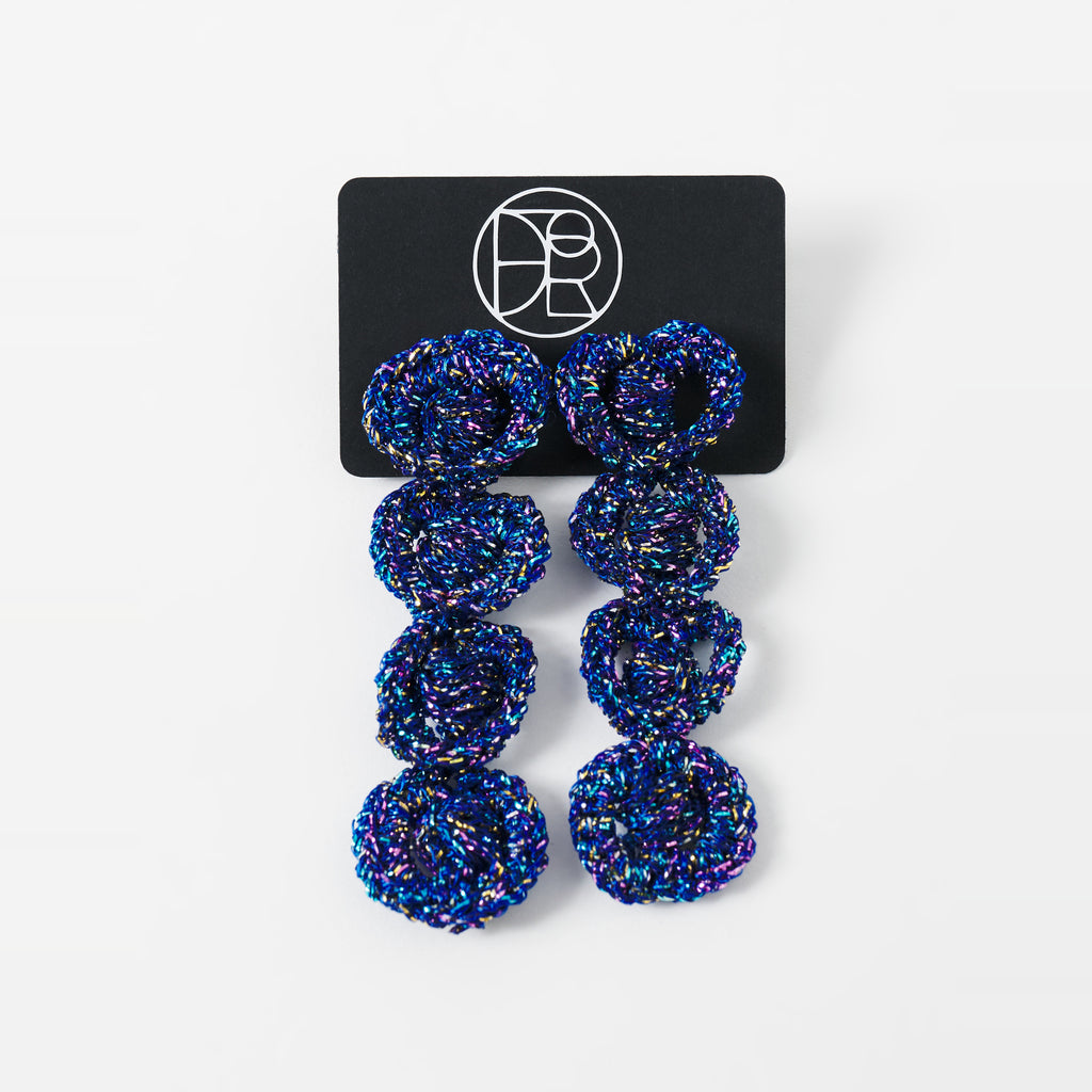 The Arlo long indigo blue four-ring crochet loop earrings displayed on a black earring card - Lodorfo