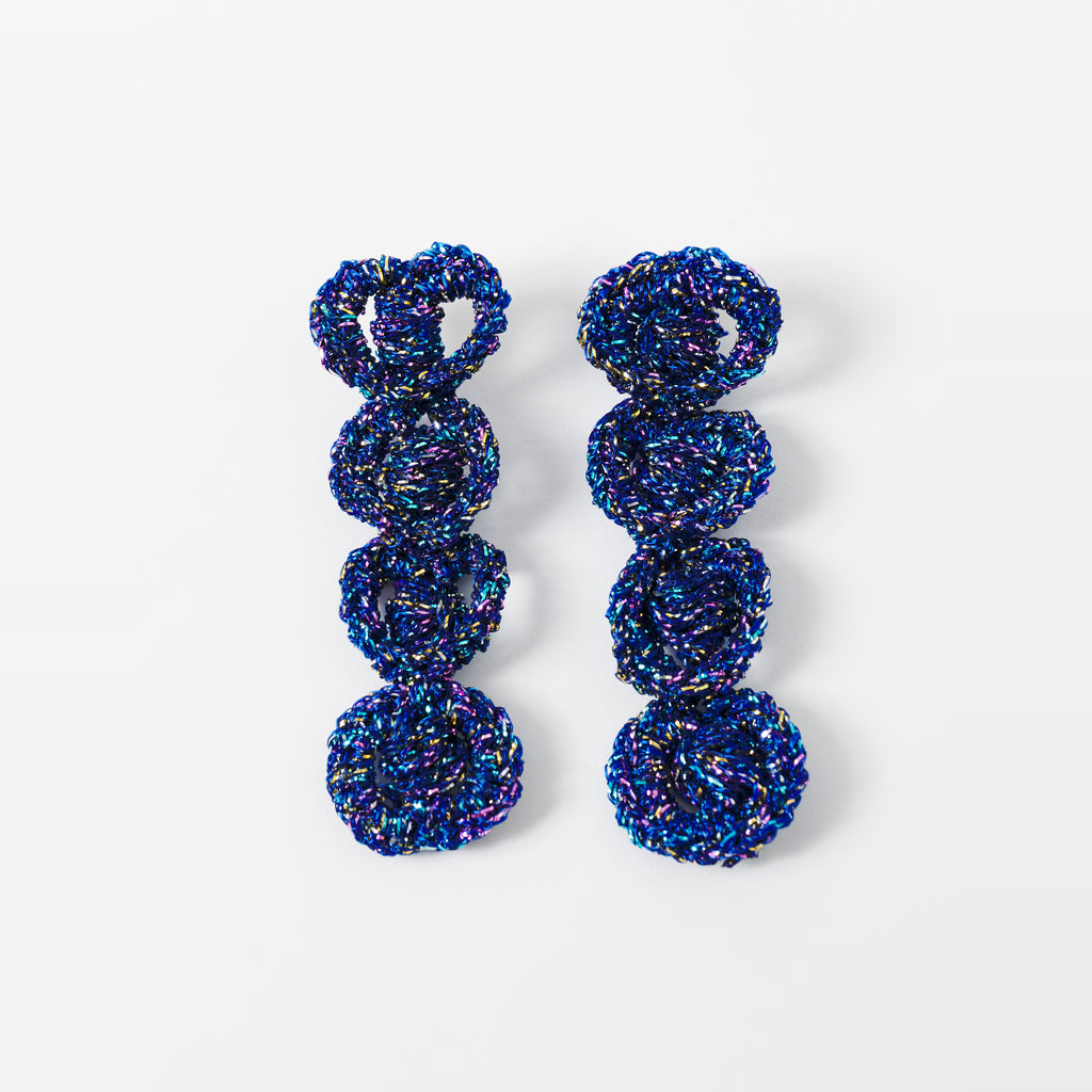 The Arlo long indigo blue four-ring crochet loop earrings laid flat - Lodorfo