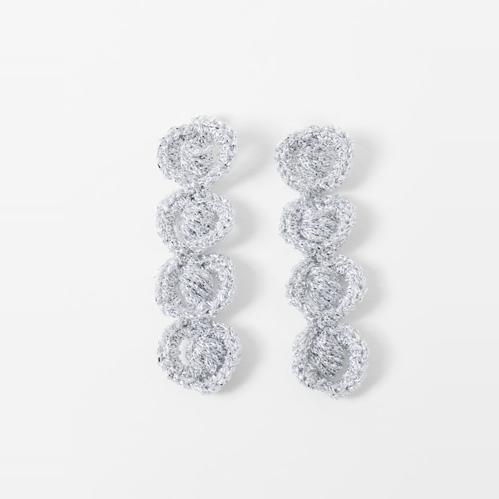 The Arlo long silver grey four-ring crochet loop earrings laid flat - Lodorfo