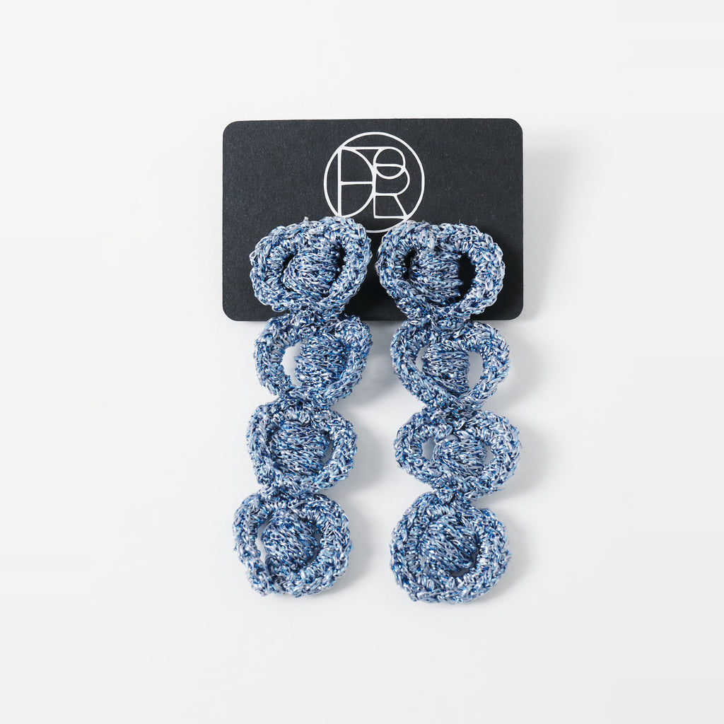 The Arlo long sky blue four-ring crochet loop earrings displayed on a black earring card - Lodorfo