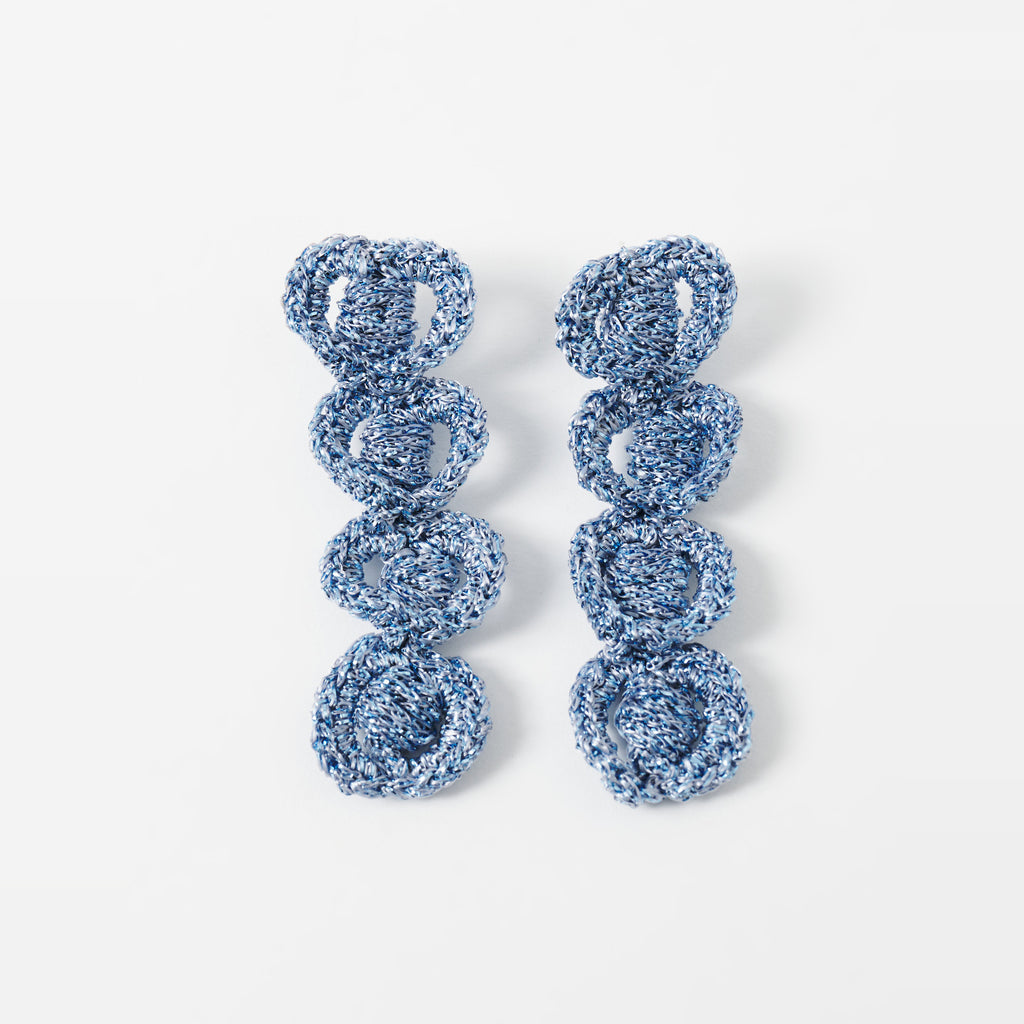 The Arlo long sky blue four-ring crochet loop earrings laid flat - Lodorfo