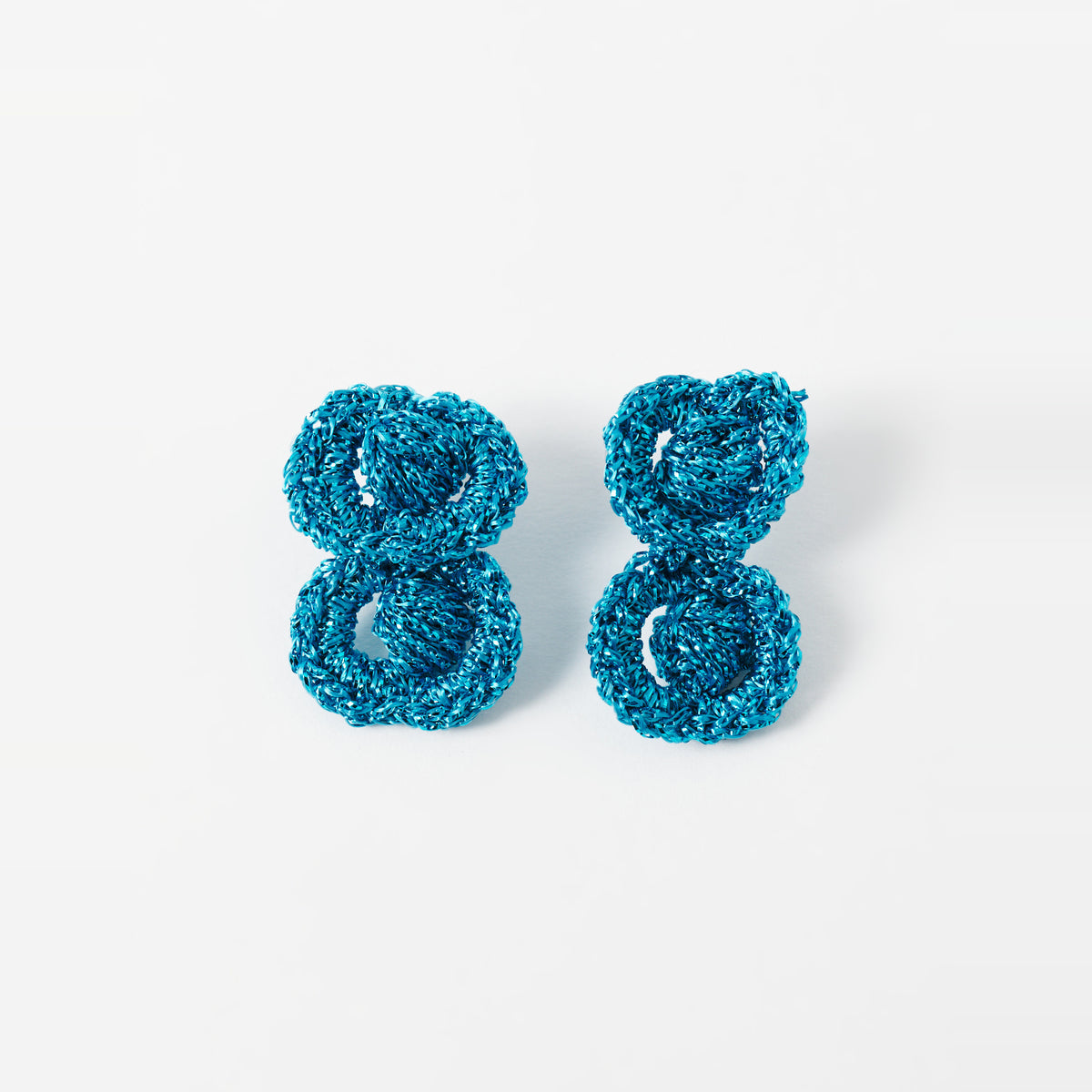 The Arlo short deep teal two-ring crochet loop earrings laid flat - Lodorfo