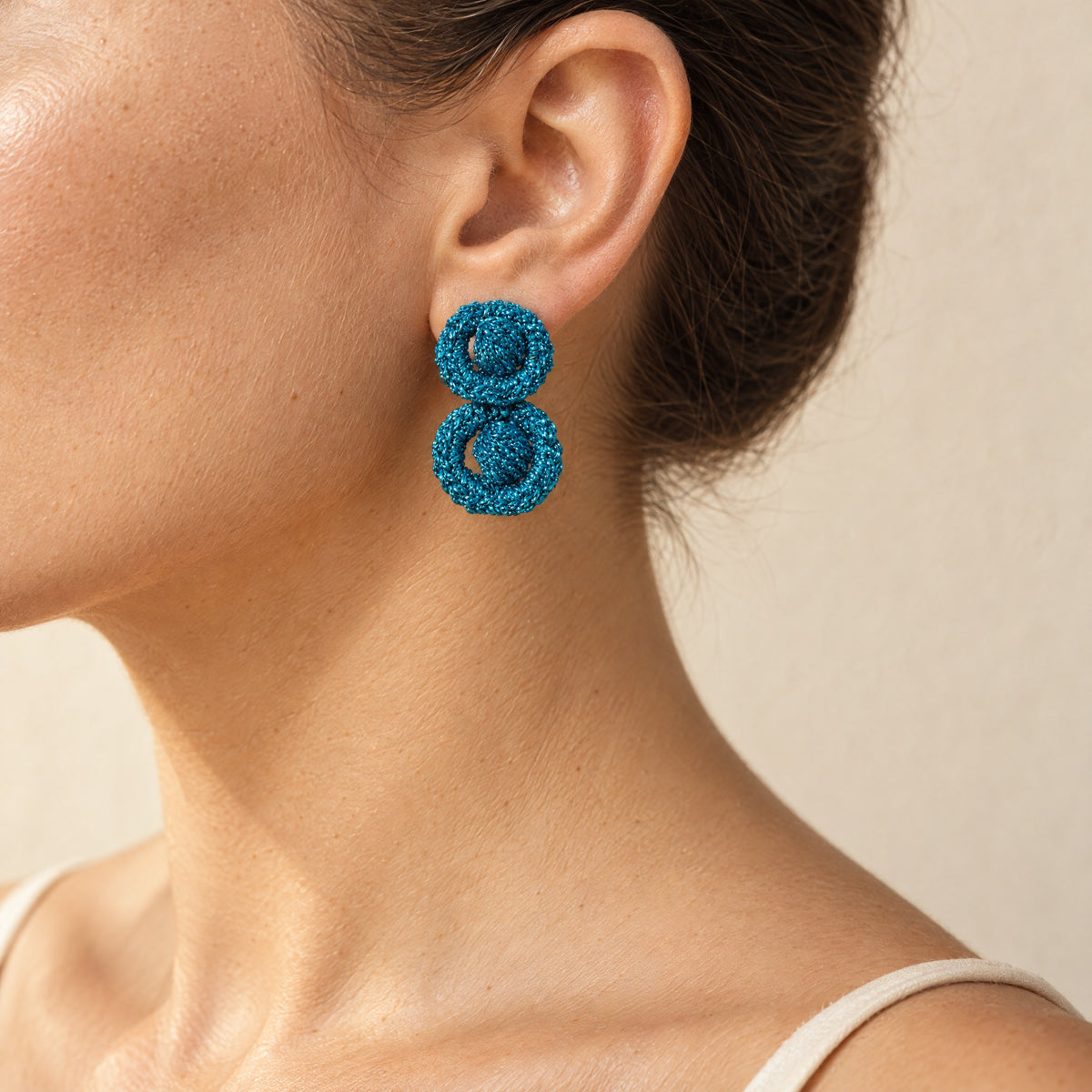 Woman wearing the Arlo short deep teal two-ring crochet loop earring, handmade UK - Lodorfo