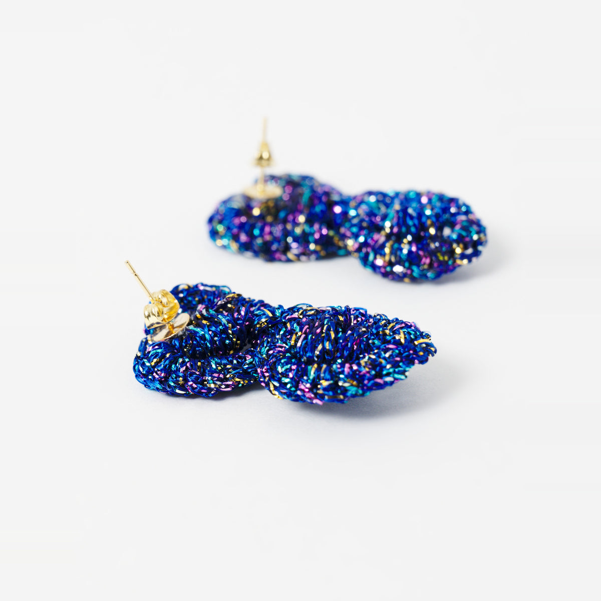 Close-up of the Arlo short indigo blue two-ring crochet loop earrings, showing the stud posts - Lodorfo