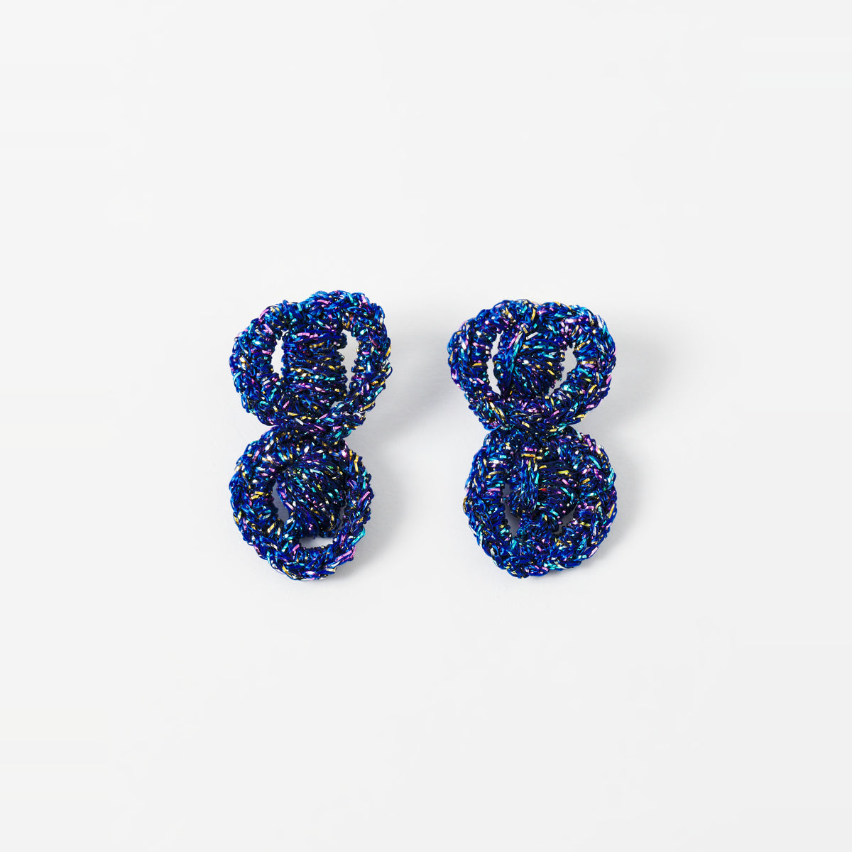 The Arlo short indigo blue two-ring crochet loop earrings laid flat - Lodorfo