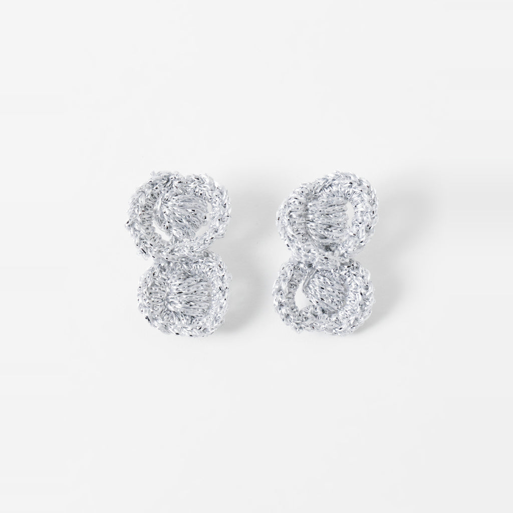The Arlo short silver grey two-ring crochet loop earrings laid flat - Lodorfo