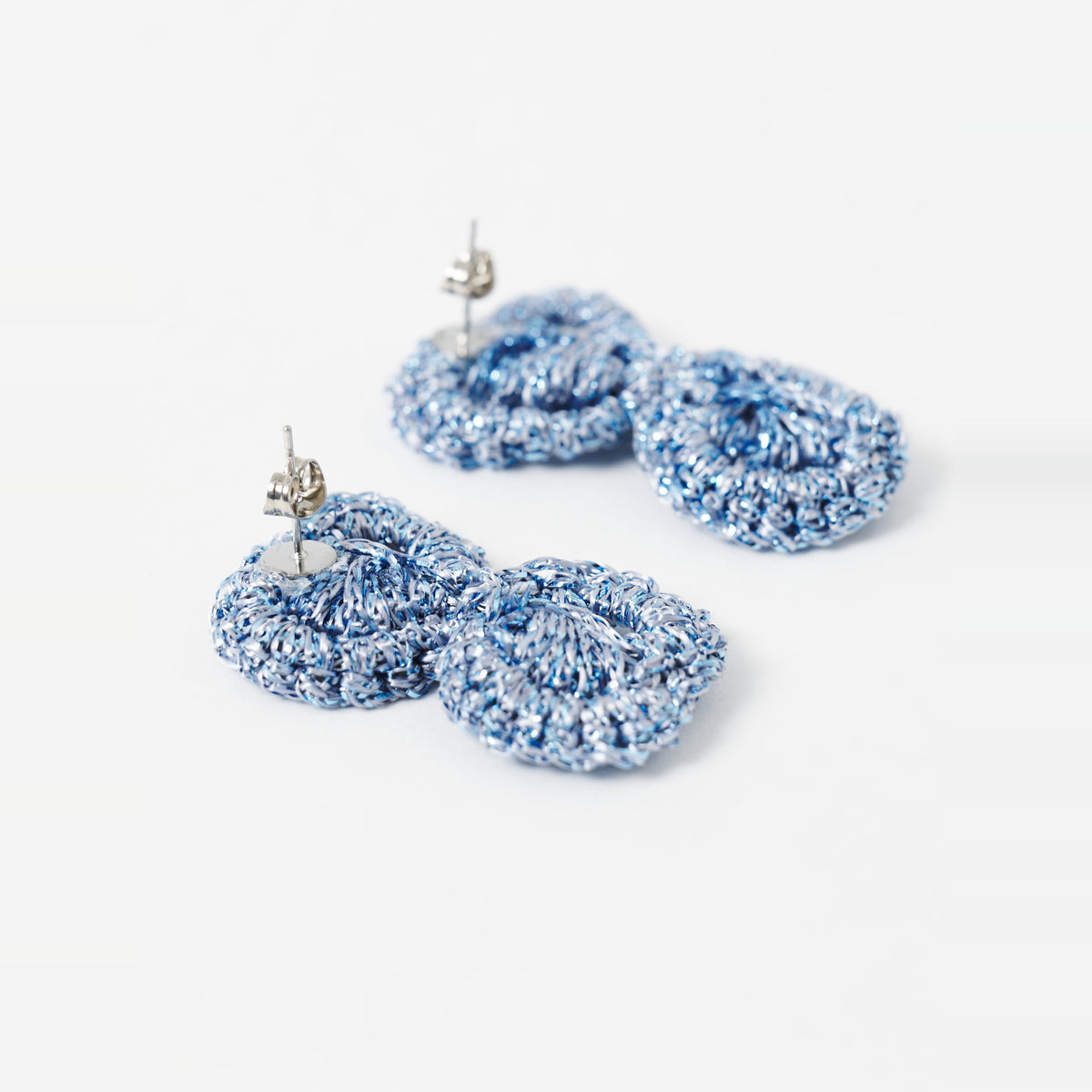 Close-up of the Arlo short sky blue two-ring crochet loop earrings, showing the stud posts - Lodorfo