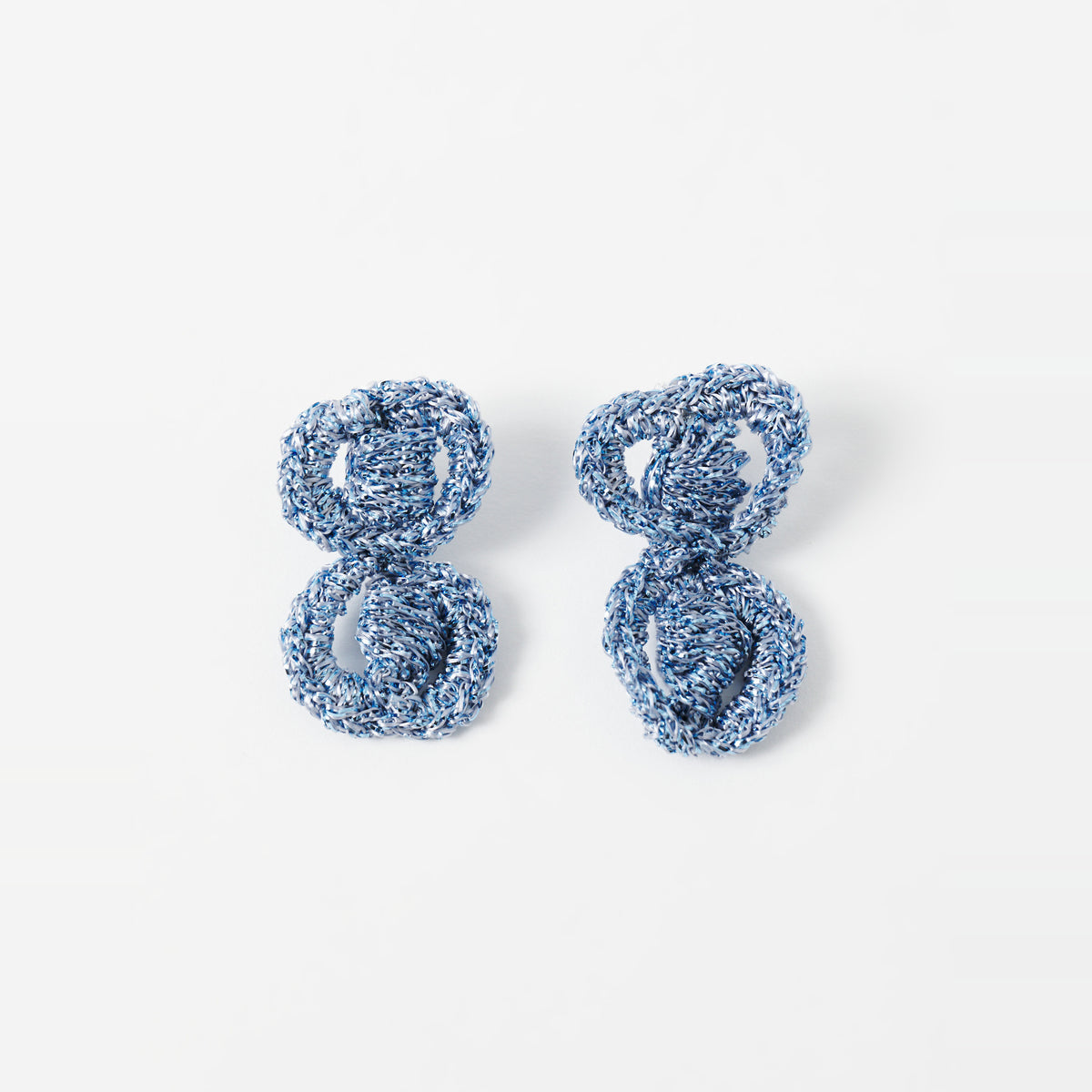 The Arlo short sky blue two-ring crochet loop earrings laid flat - Lodorfo