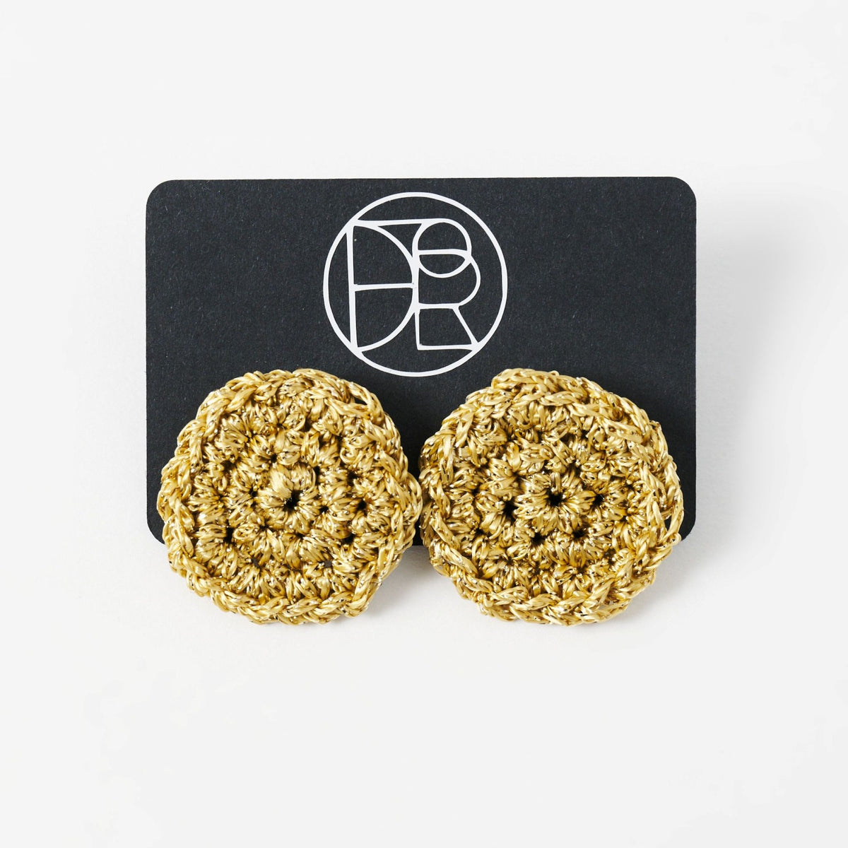 The Vela crochet disc earrings in antique gold shimmer, styled display - Lodorfo
