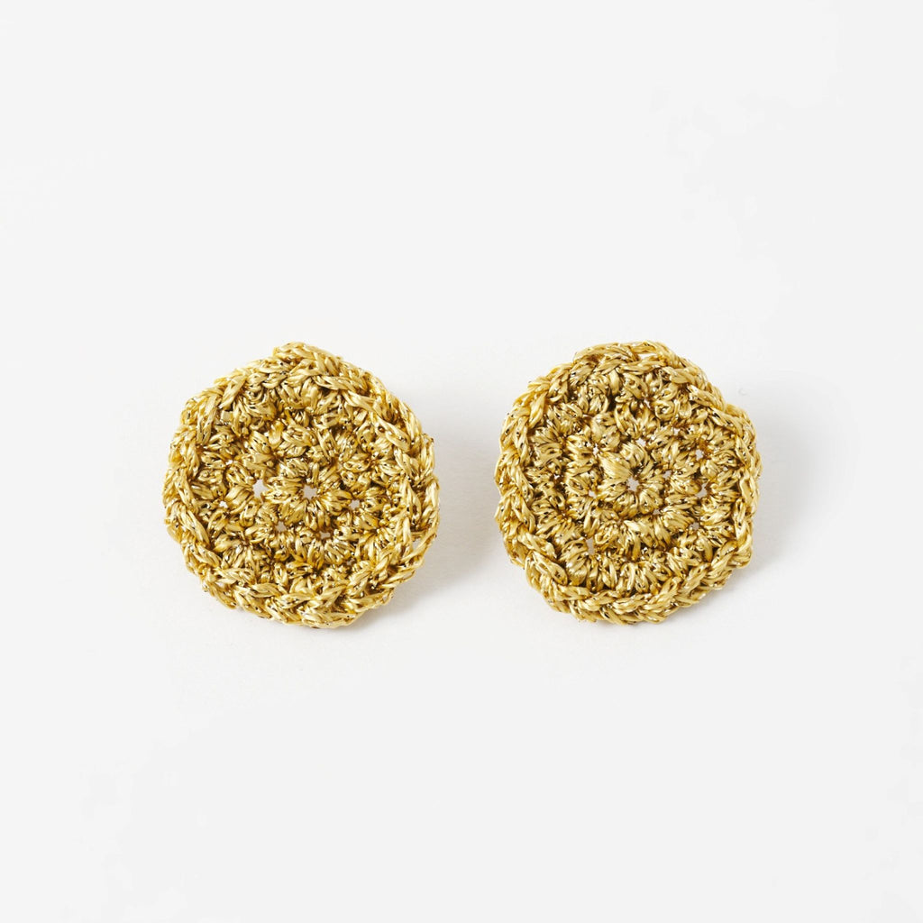 The Vela crochet disc earrings in antique gold shimmer, flat lay - Lodorfo