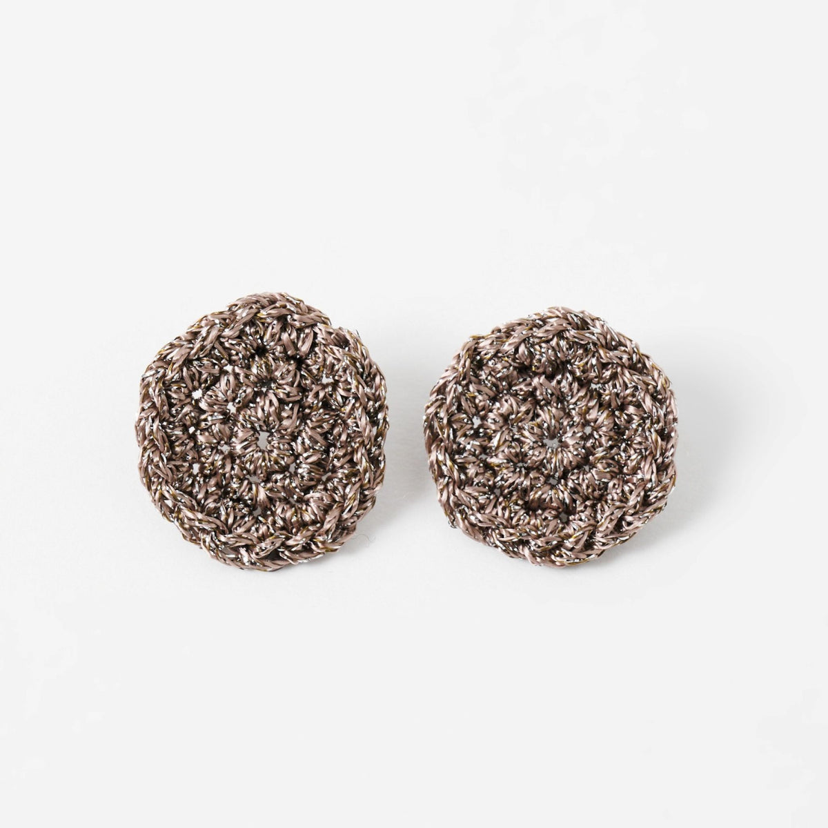 The Vela crochet disc earrings in fawn with silver shimmer, flat lay - Lodorfo
