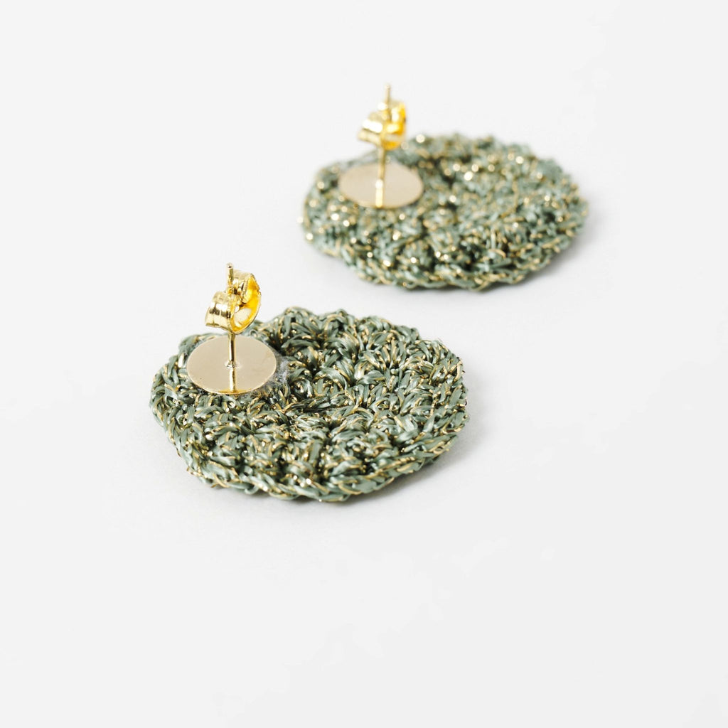 Close-up of the hand-crocheted texture of the Vela disc earrings in forest green with gold shimmer - Lodorfo