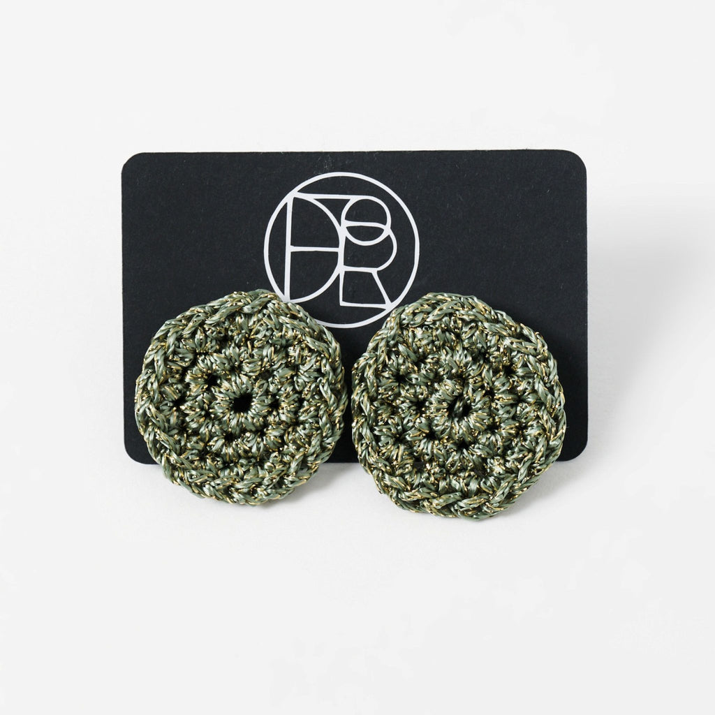 The Vela crochet disc earrings in forest green with gold shimmer, styled display - Lodorfo