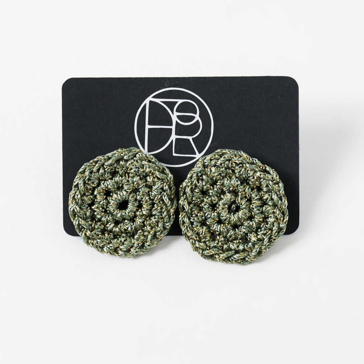 The Vela crochet disc earrings in forest green with gold shimmer, styled display - Lodorfo