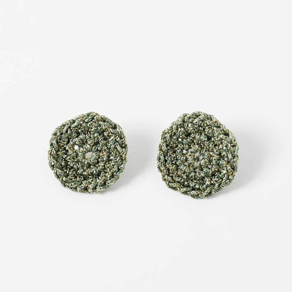 The Vela crochet disc earrings in forest green with gold shimmer, flat lay - Lodorfo
