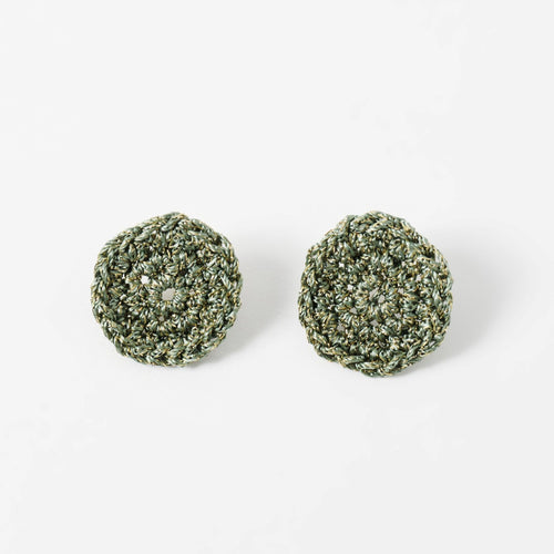 The Vela crochet disc earrings in forest green with gold shimmer, flat lay - Lodorfo