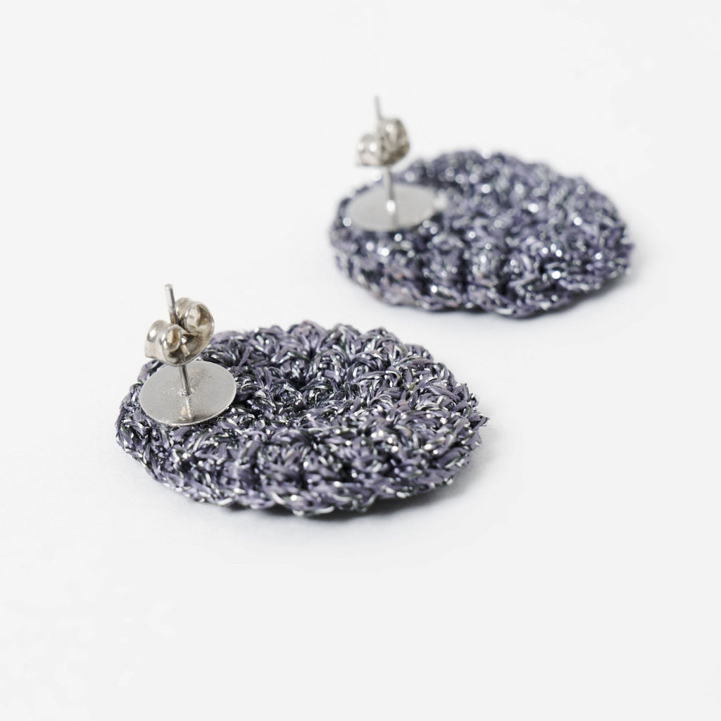 Close-up of the hand-crocheted texture of the Vela disc earrings in graphite grey with silver shimmer - Lodorfo