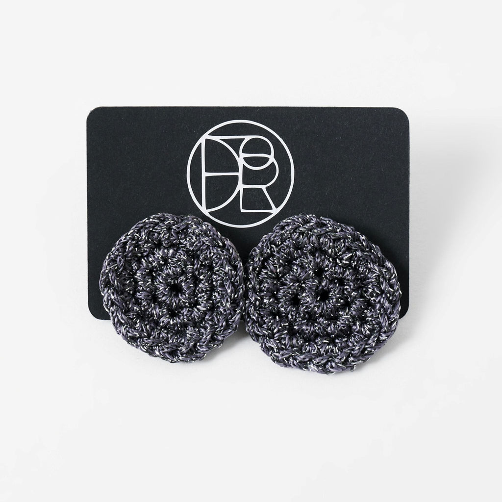 The Vela crochet disc earrings in graphite grey with silver shimmer, styled display - Lodorfo