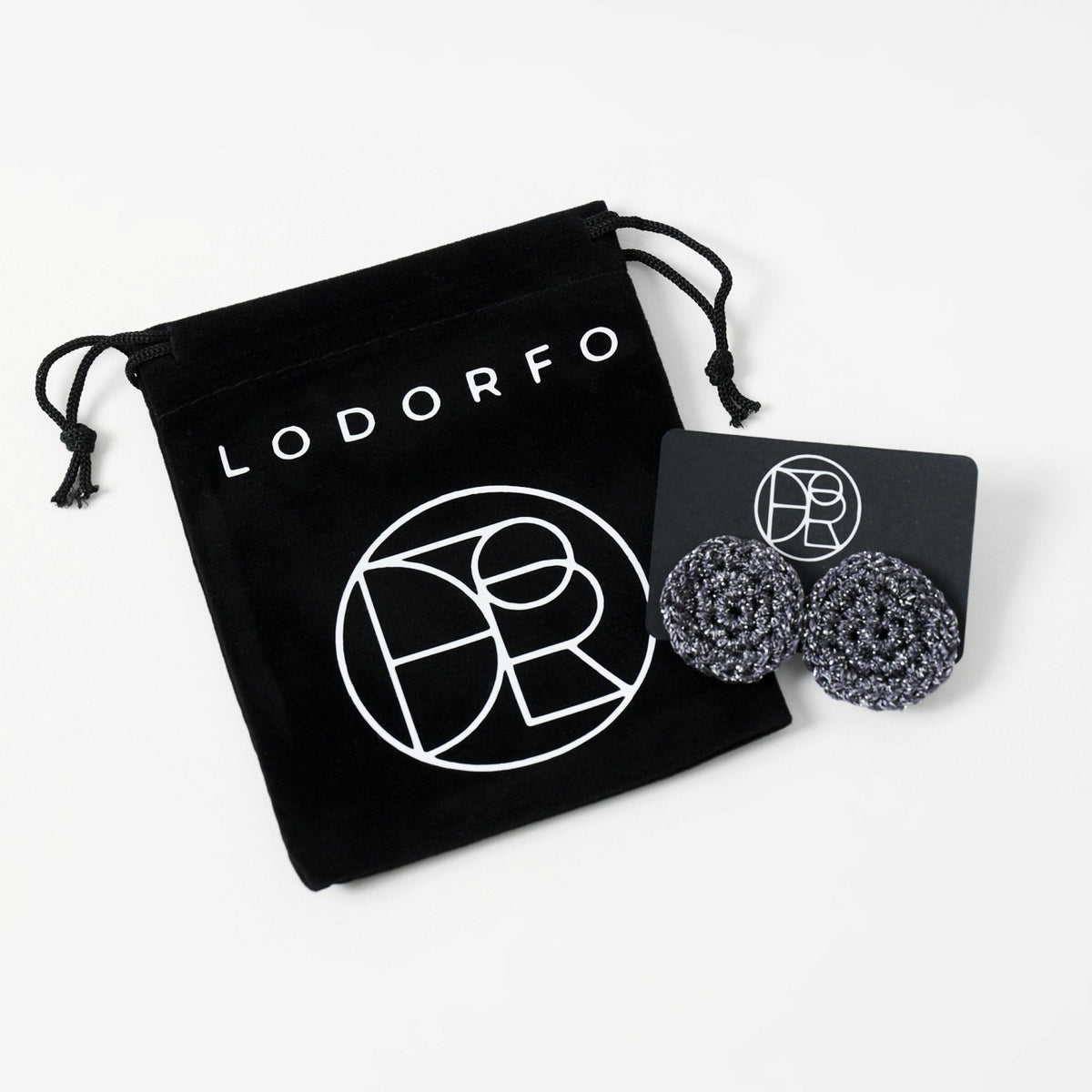 The Vela crochet disc earrings in graphite grey with silver shimmer, styled display, second view - Lodorfo