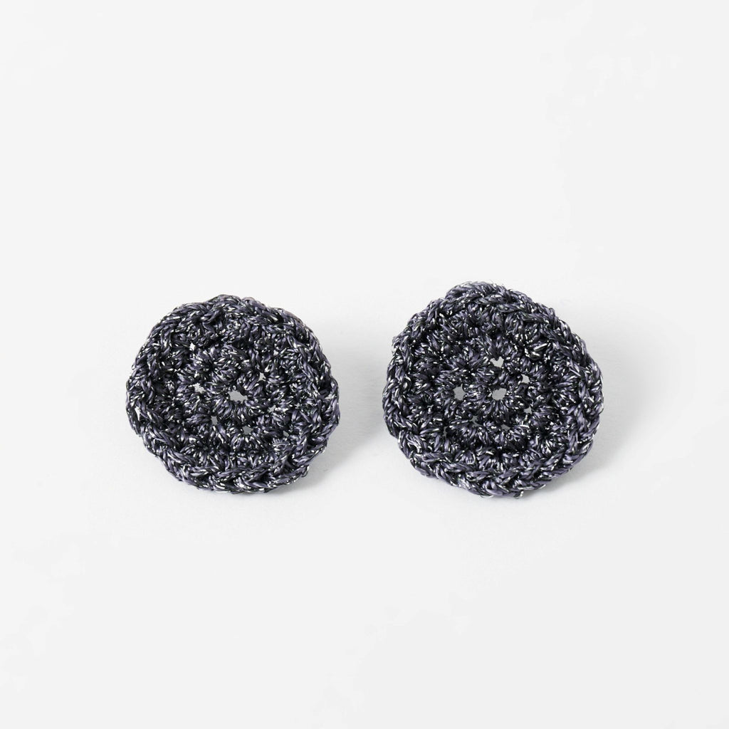 The Vela crochet disc earrings in graphite grey with silver shimmer, flat lay - Lodorfo
