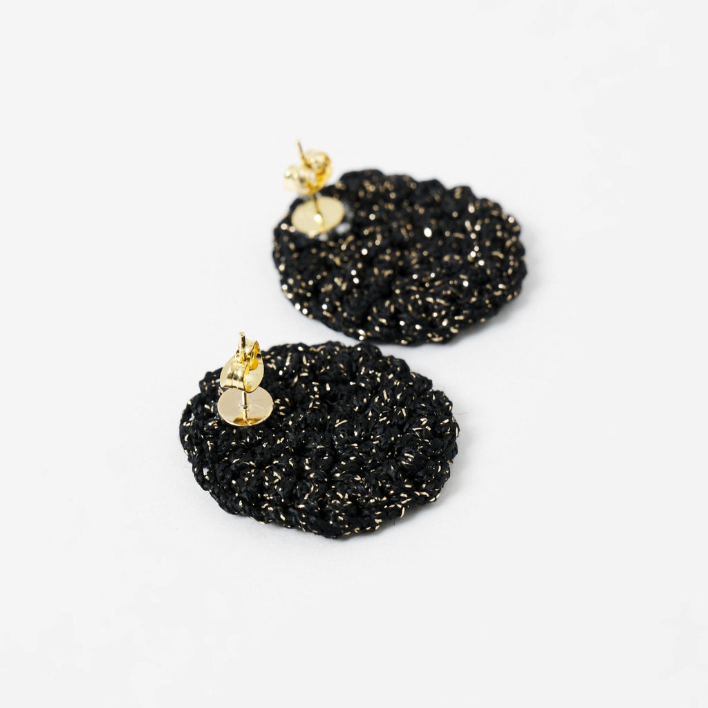 Close-up of the hand-crocheted texture of the Vela disc earrings in midnight black with gold shimmer - Lodorfo