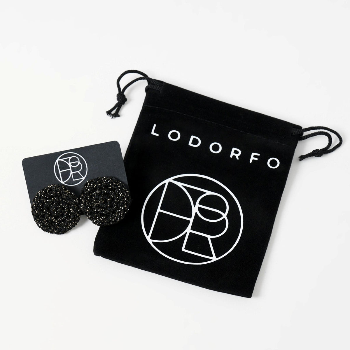 The Vela crochet disc earrings in midnight black with gold shimmer, styled display, second view - Lodorfo