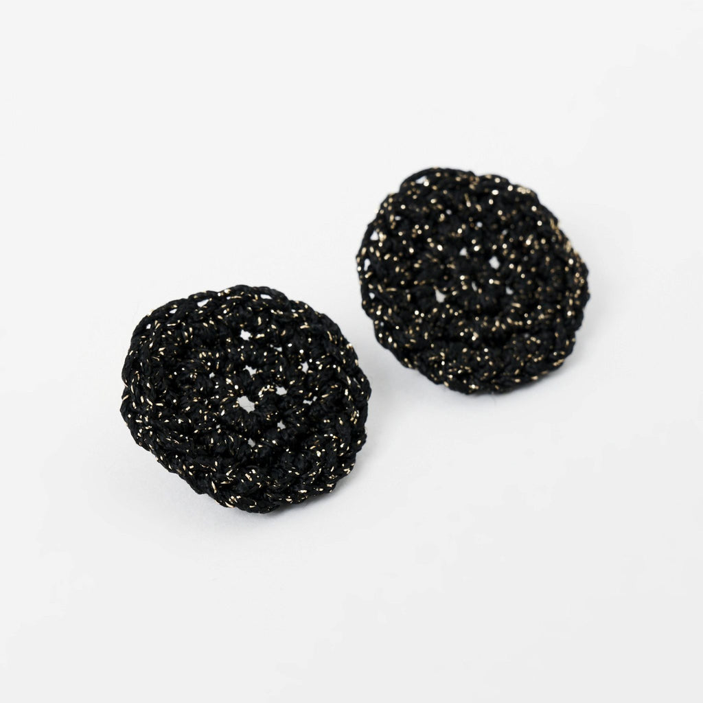 The Vela crochet disc earrings in midnight black with gold shimmer, flat lay, second view - Lodorfo