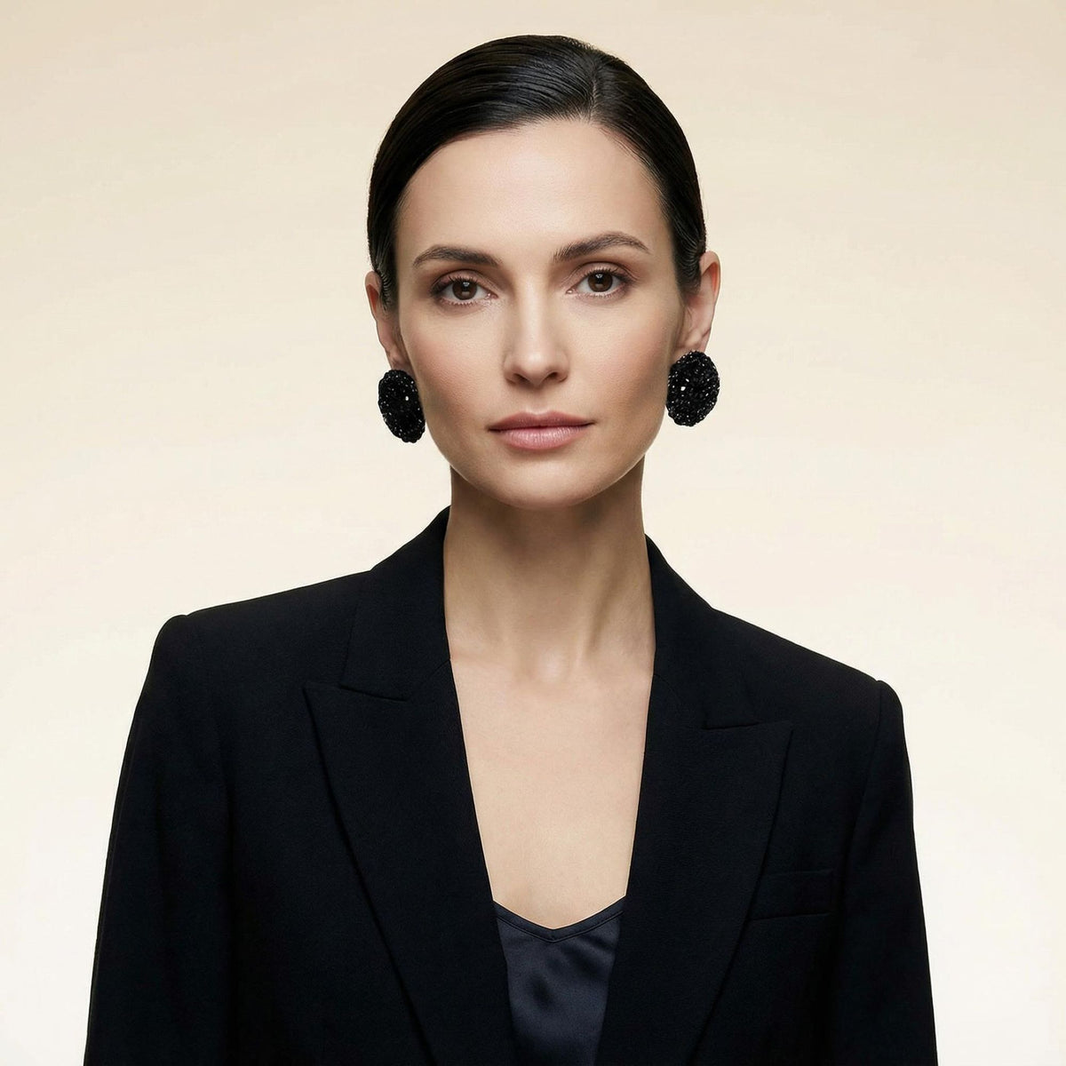 Woman wearing the Vela crochet disc earrings in midnight black with gold shimmer, street style - Lodorfo