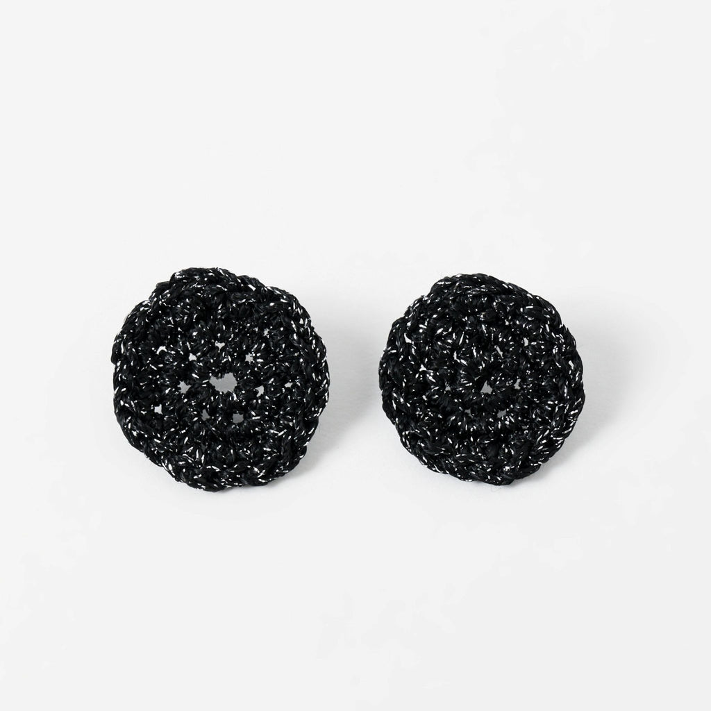 The Vela crochet disc earrings in midnight black with silver shimmer, flat lay - Lodorfo