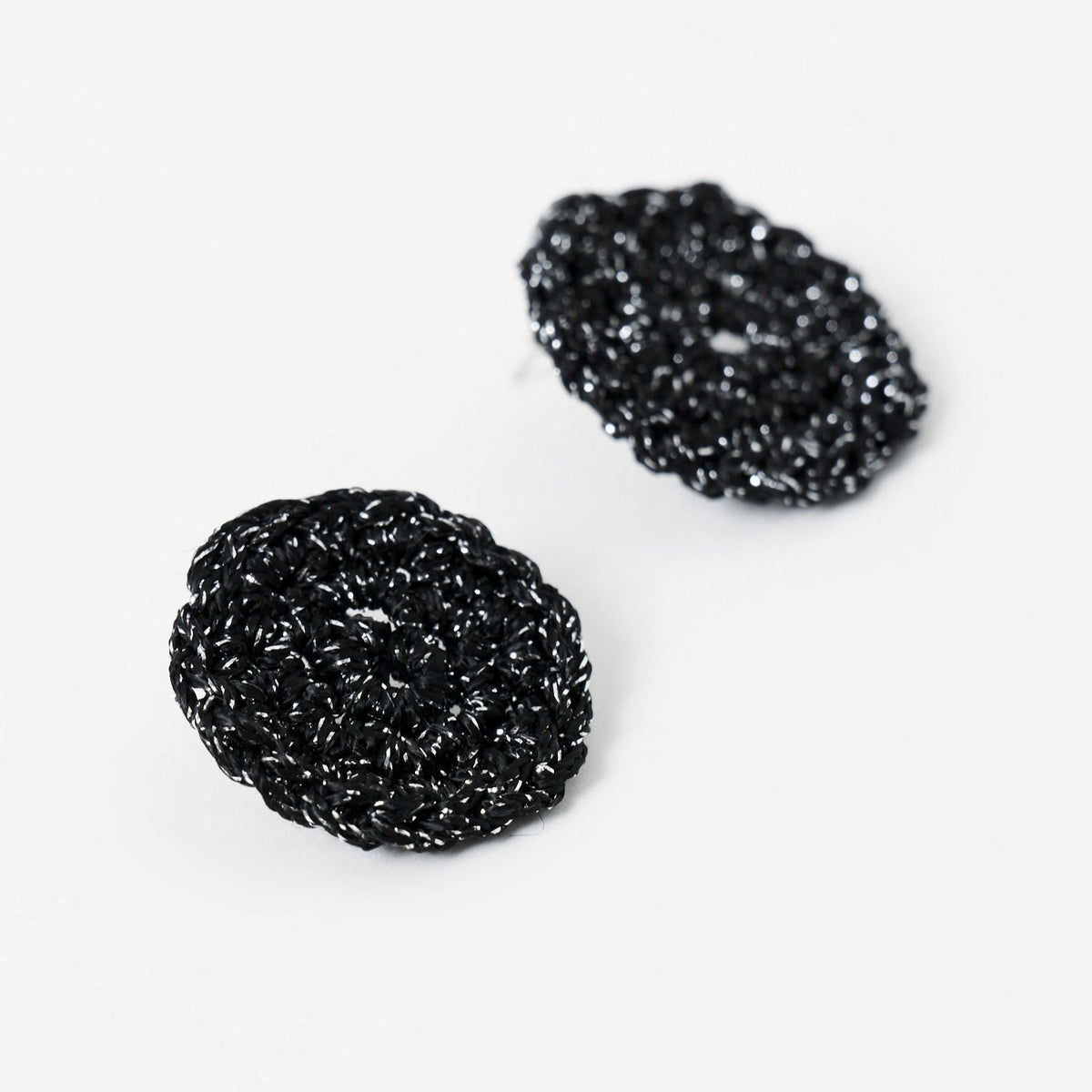 The Vela crochet disc earrings in midnight black with silver shimmer, flat lay, second view - Lodorfo