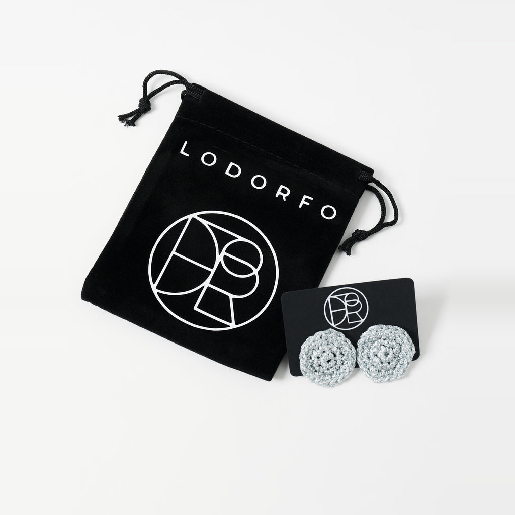 The Vela crochet disc earrings in pebble grey with silver shimmer, styled display, second view - Lodorfo